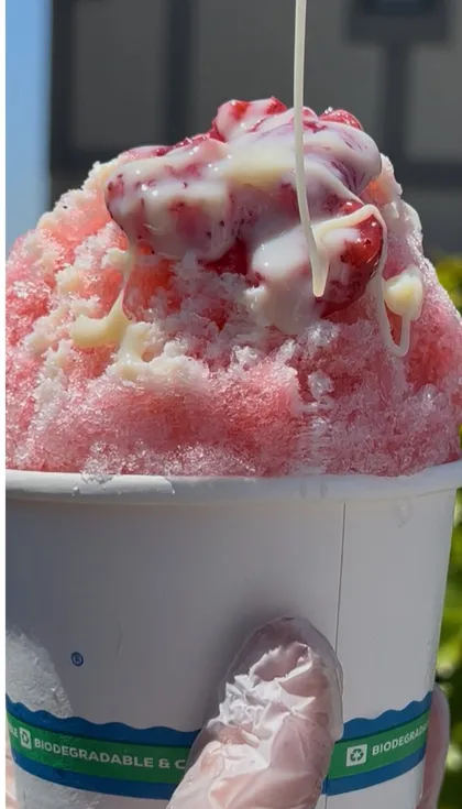 Pouring cream over strawberry Hawaiian shave ice